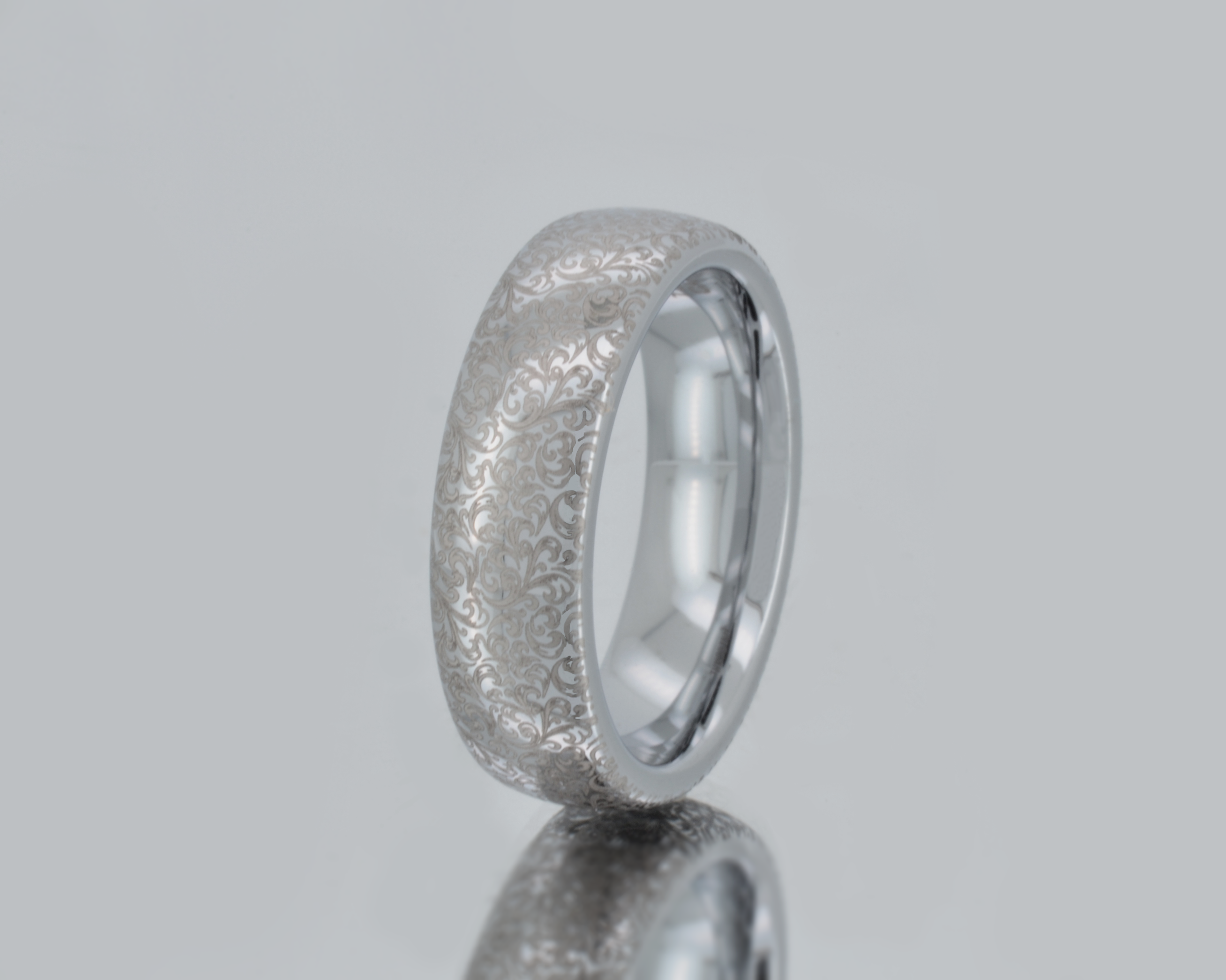 Silver ring with textured surface on a gray background