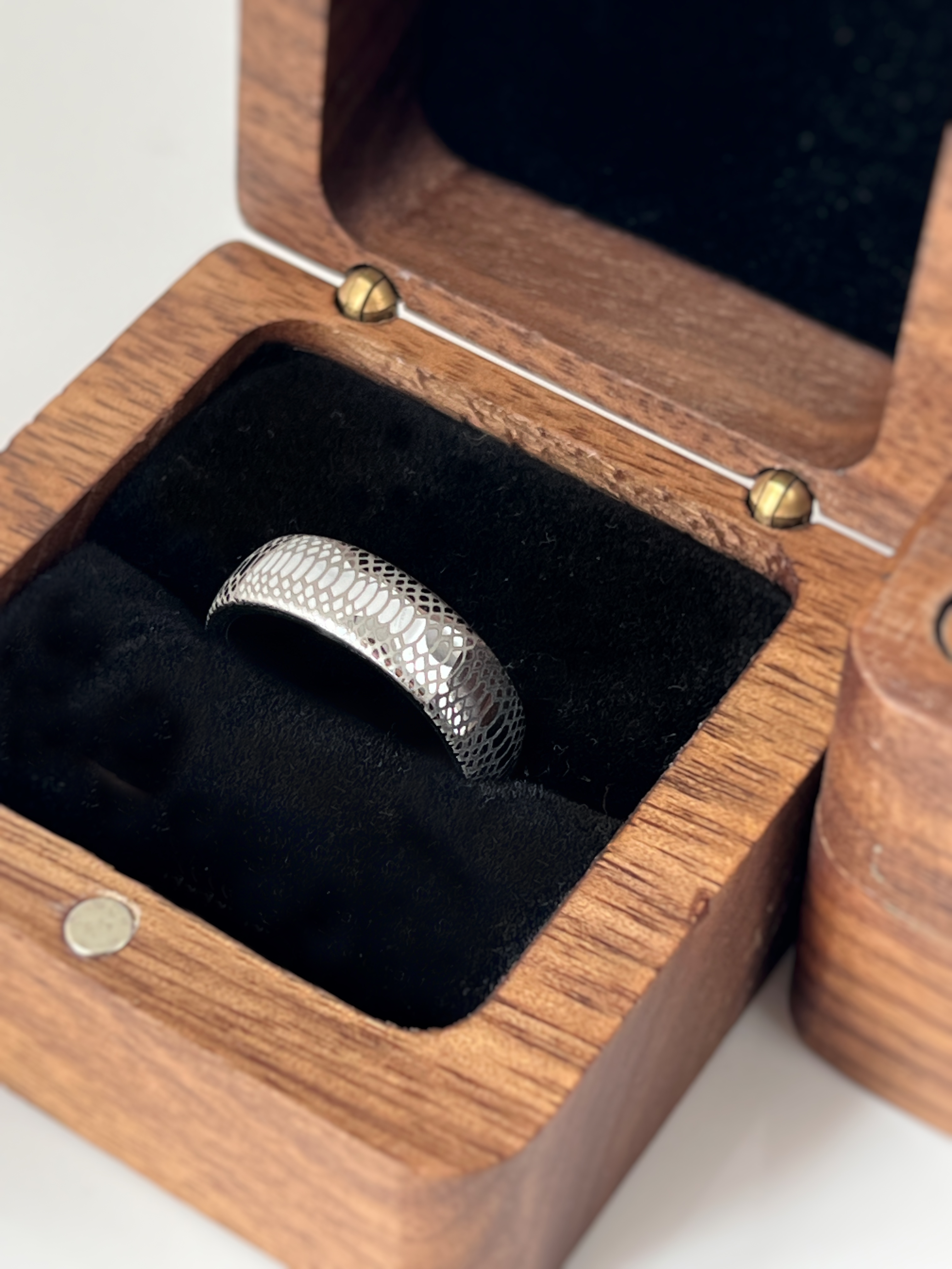 Tungsten carbide ring Serpente Eterno with snake scale pattern, presented in a luxurious wooden ring box lined with black velvet. Perfect for men's wedding band or statement jewelry.