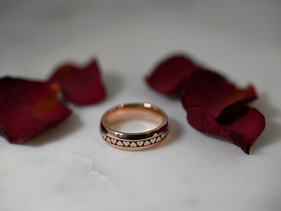Rose gold-tone HoloRing with a heart pattern among rose petals
