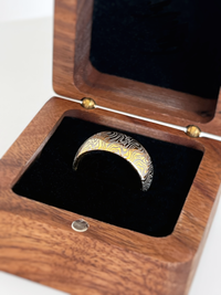 Product photo of the Golden Mokume Majesty tungsten ring with laser-engraved surface detail.