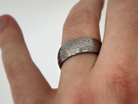 Silver tungsten ring with an engraved mountain range design, isolated on a white background.