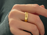 High Polished Yellow Gold Tungsten Wedding Band with a polished plain surface, worn on a hand.