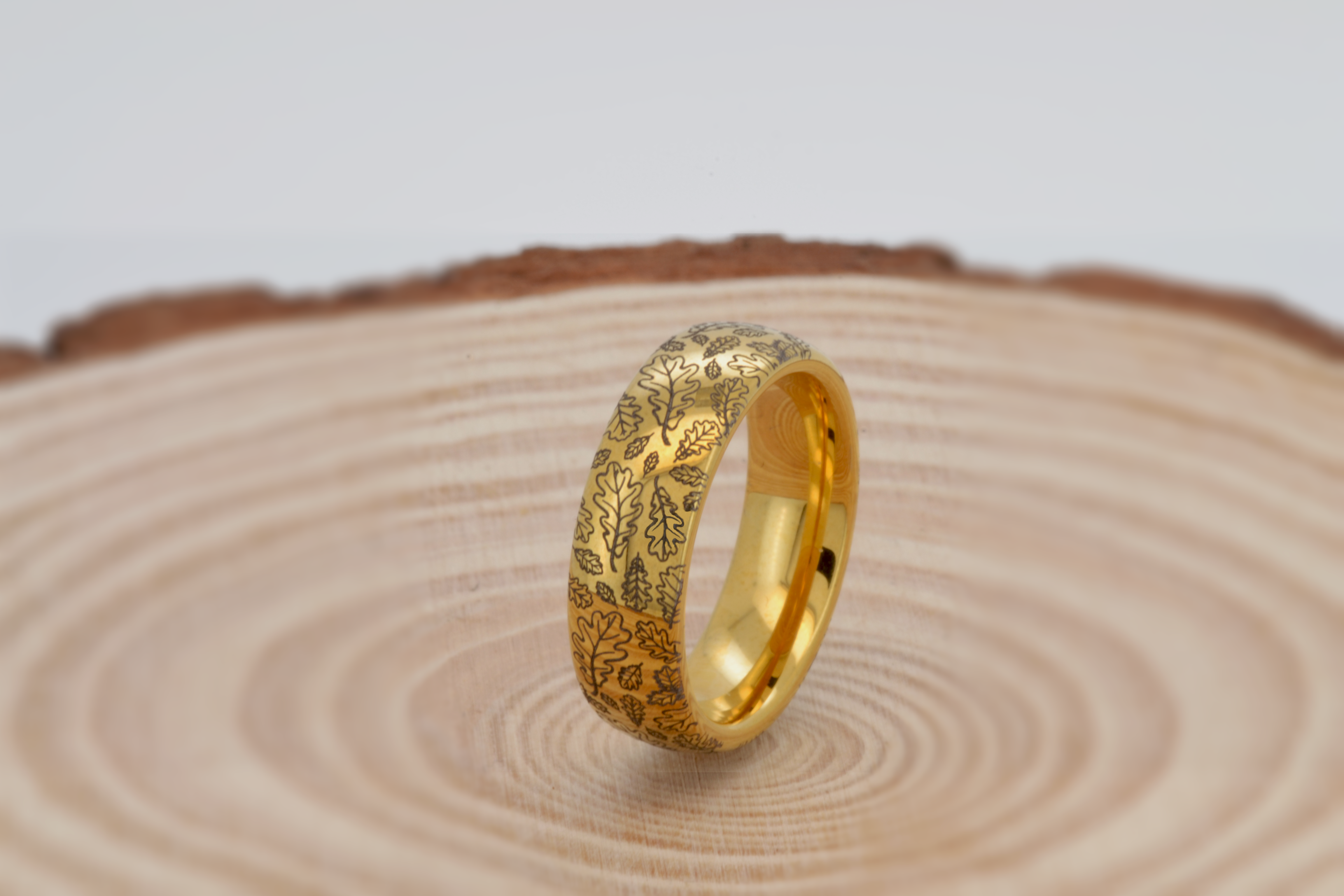 Elegant gold ring with intricate oak leaf engraving. This tungsten ring features a detailed oak leaf pattern that symbolizes strength and endurance. Perfect as a unique wedding band or stylish everyday accessory. High-quality craftsmanship combined with the durability of tungsten and the timeless appeal of gold.