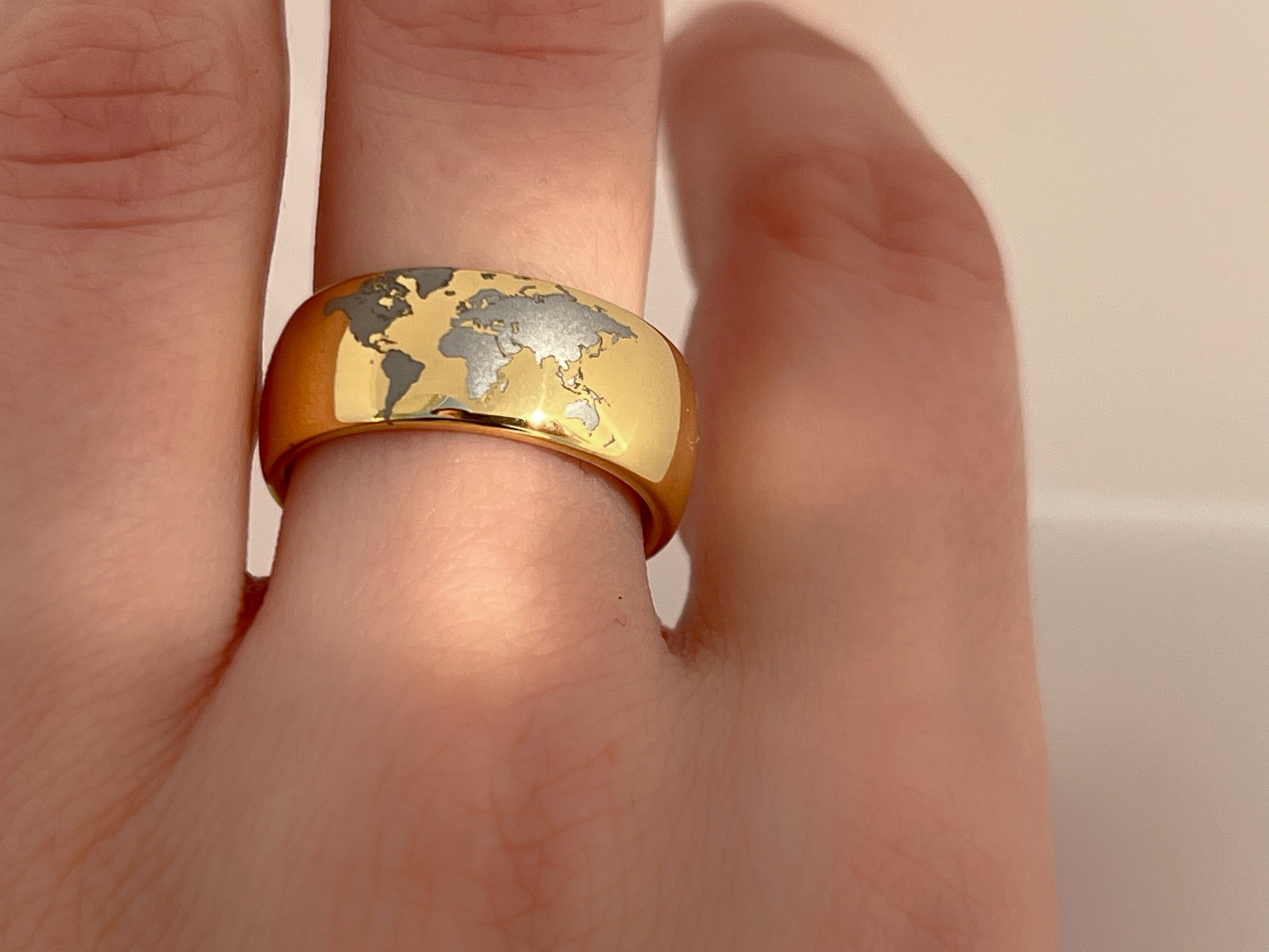 Highly polished Yellow gold tungsten ring with unique elegant white engraving of earth continents. An ideal elegant gift for travellers and adventurers. Premium anniversary wedding band for special occasion or engagement. Luxury promise ring for friend, girlfriend, mother, mom or granny. Ideal original personalized present for her and him