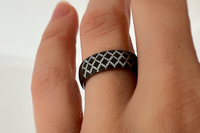 White gold tungsten ring with black engraved quilted pattern worn on hand