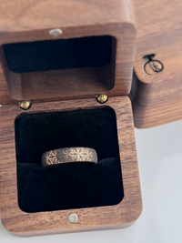 Product photo of the Petal Dance tungsten ring with laser-engraved surface detail.