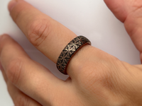 Petal Dance tungsten ring with laser-engraved surface detail, worn on a hand.