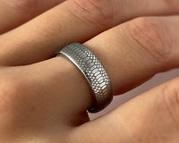 Serpente Eterno tungsten ring with laser-engraved surface detail, worn on a hand.