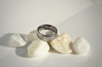 Product photo of the White Gold Quilted Elegance tungsten ring with laser-engraved surface detail.