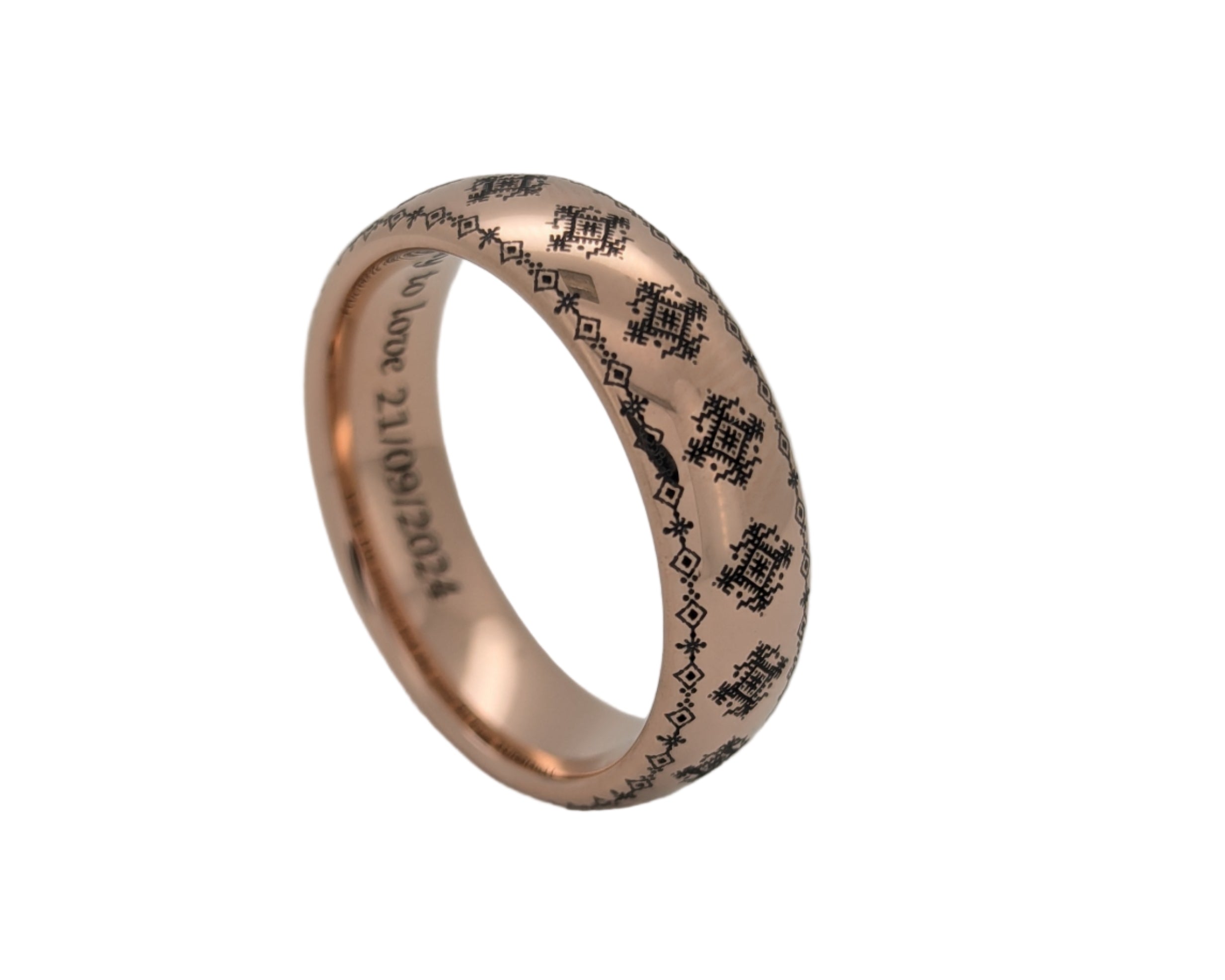 Rose gold ring with engraved design on a light gray background