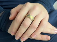 Golden Mokume Majesty tungsten ring with laser-engraved surface detail, worn on a hand.