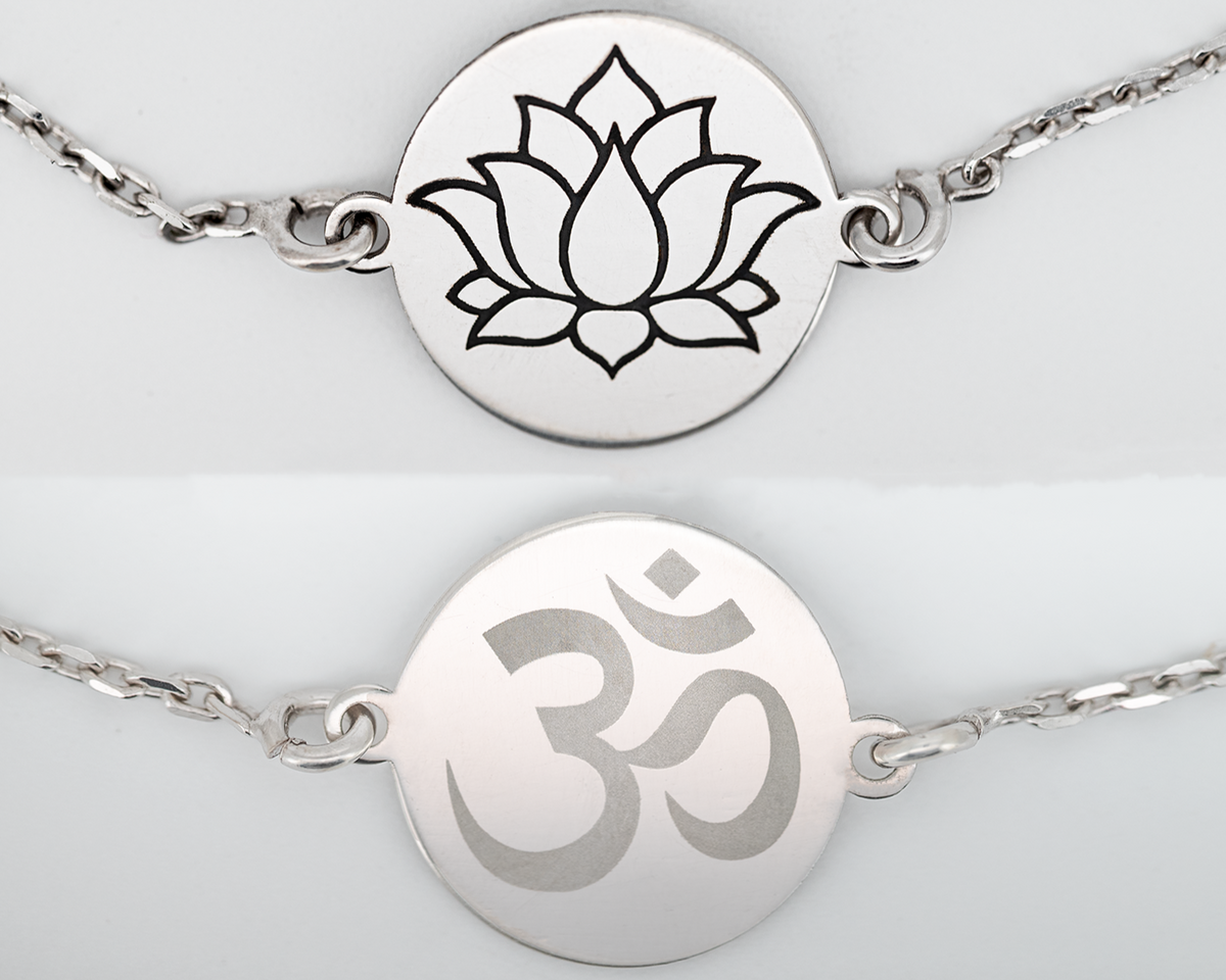 Personalisiertes silberfarbenes Armband mit graviertem Om-Symbol und Lotusmotiv.