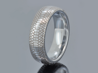 Product photo of the Serpente Eterno tungsten ring with laser-engraved surface detail.