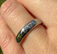 HoloHearts tungsten carbide ring worn on a finger, showing the laser-created holographic heart pattern shifting color in the light.