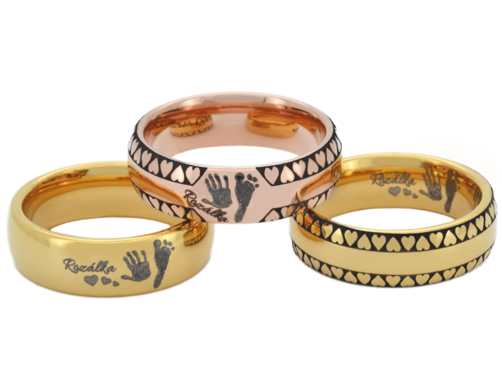 A collection of tungsten rings in gold and rose gold finishes, each engraved with a unique pattern. All of them features a child's handprint and footprint, one is plain, another is adorned with hearts and has inner imprint, and the third has hearts with outer imprint, emphasizing the personal and sentimental value of these custom-made pieces.