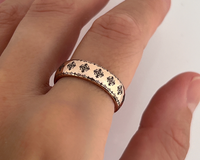 Close-up of a hand wearing a rose gold tungsten ring with engraved traditional ornamental pattern, photographed against a white background.