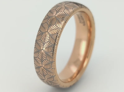 Video of Rose gold tungsten ring with an intricate, white-engraved petal-like pattern, on a white background offering a delicate and refined look, perfect for weddings, special occasions, or everyday wear.