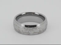Silver tungsten ring with an engraved mountain range design, isolated on a white background.